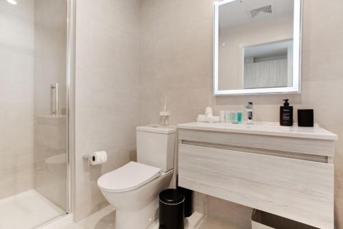 a bathroom with a toilet and a sink and a mirror at Augustus Hideaway Studio Apt with Air-Con in Auckland