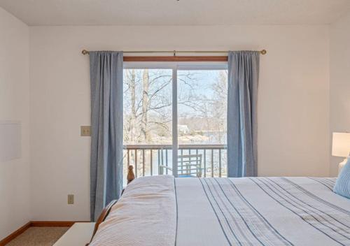 a bedroom with a bed and a large window at Lucky Dozen Lakehouse in Winchester