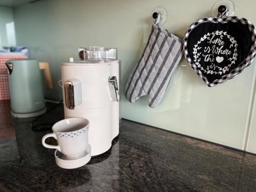 a coffee maker and a cup on a counter at Chaletwohnung im Luzerner Seetal mit Platz, Charm und Erholungswert in Ballwil