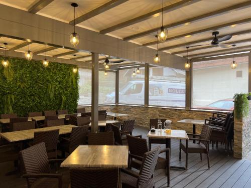 un ristorante con tavoli, sedie e finestre di Gostisce Sovdat a Bovec
