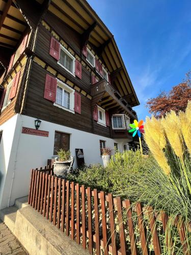 a wooden house with a fence in front of it at Chaletwohnung im Luzerner Seetal mit Platz, Charm und Erholungswert in Ballwil