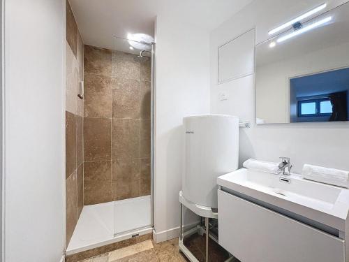 une salle de bain blanche avec un lavabo et une douche dans l'établissement Appartement gare 4 pers tout équipé N2, à Clermont-Ferrand