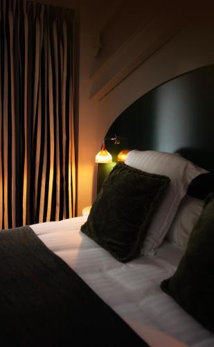 a bedroom with a bed with a black and white pillow at Hôtel Kemaris in Biarritz
