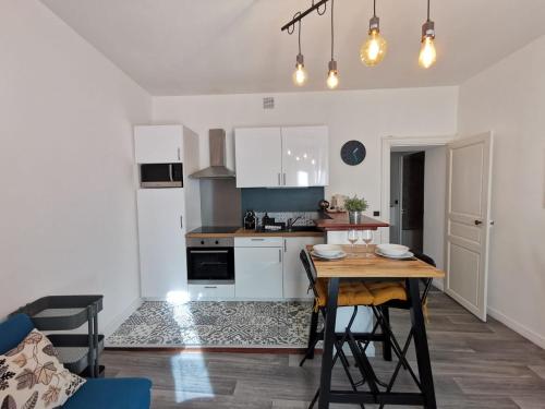 une cuisine et une salle à manger avec une table et des chaises dans l'établissement Nouveau - Sarrazin, à Nantes