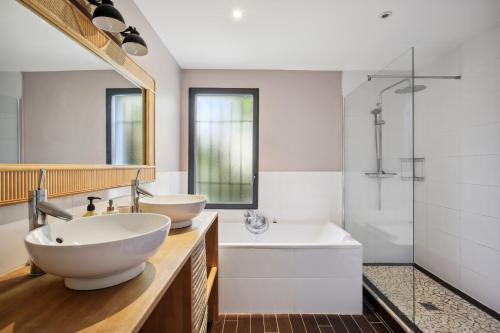 une salle de bain avec deux lavabos, une baignoire et une douche dans l'établissement Charming country house swimming pool 17 min from Bordeaux, à Latresne