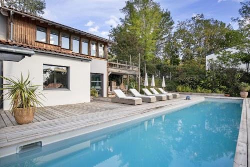 une piscine avec des chaises longues et une maison dans l'établissement Charming country house swimming pool 17 min from Bordeaux, à Latresne