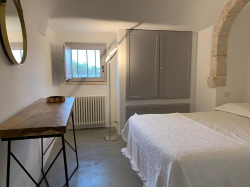 a bedroom with a bed and a mirror and a window at Trulli Mansueto in Noci