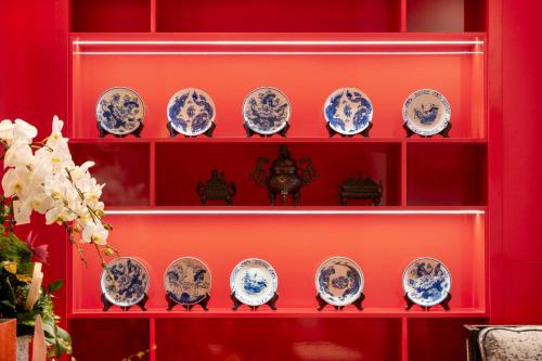 a red shelf with blue and white plates on it at Hanoi Bliss Hotel in Hanoi