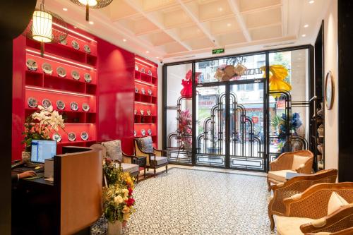 a room with red walls and a window with plates at Hanoi Bliss Hotel in Hanoi