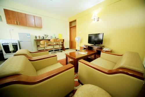 a living room with two couches and a television at Hotel Africana in Kampala