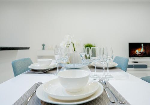 a dining room table with plates and wine glasses at Bright & Chic Apartment in Libreville
