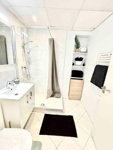une salle de bain blanche avec une douche et un lavabo dans l'établissement Adorable studio cannes center, à Cannes