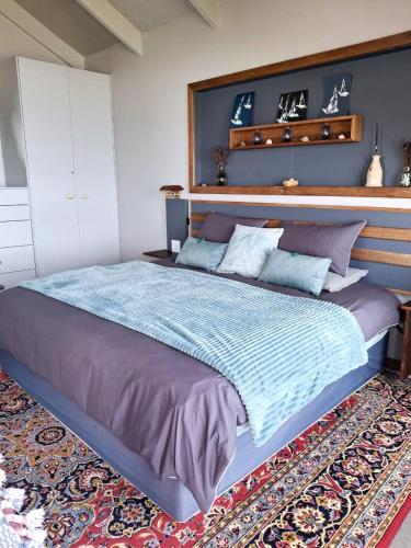 a bedroom with a large bed with a large headboard at Whalecome - Witsand Beachfront House in Witsand