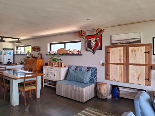 a living room with a table and a dining room at Whalecome - Witsand Beachfront House in Witsand