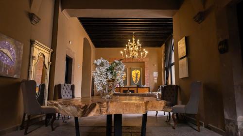 a dining room with a table with a vase of flowers on it at Hotel Plaza de Armas in Querétaro