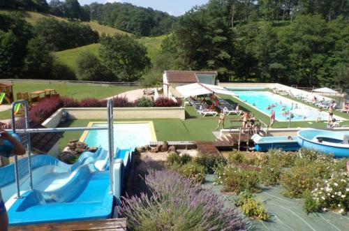 une grande piscine avec des gens dans un complexe hôtelier dans l'établissement Camping maeva Escapades Les Trois Sources, à Lamativie