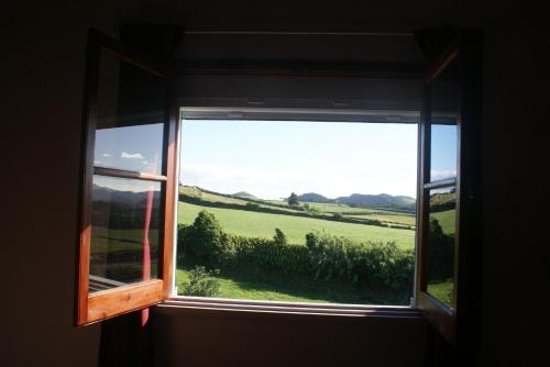 a window with a view of a green field at Green and Blue Cottage - Green Room in Ribeira Grande