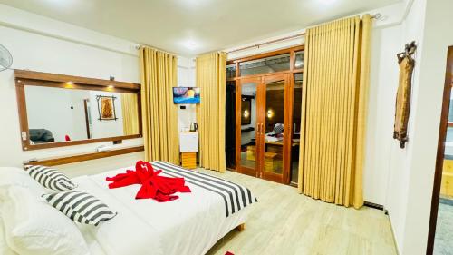 a bedroom with a bed with a red bow on it at Vibe Ella in Ella