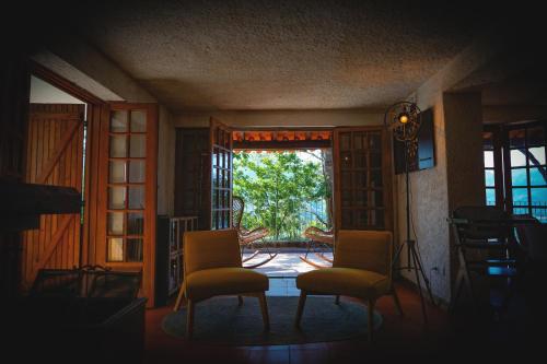 a room with two chairs and an open door at Refúgio da Caniçada - T4, Piscina Aquecida Gerês in Geres