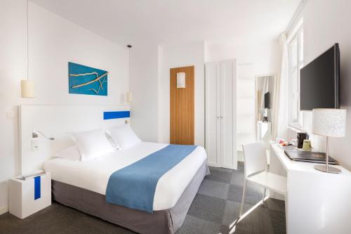 a hotel room with a bed and a desk at Hôtel Kemaris in Biarritz