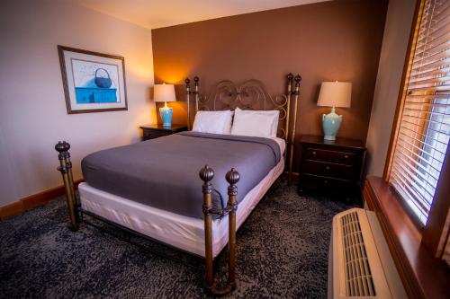 a bedroom with a bed and two lamps and a window at Nuk's Executive Suites in De Pere