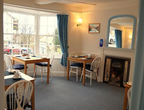 a dining room with a table and a fireplace at Radcliffe Guest House in Ross on Wye