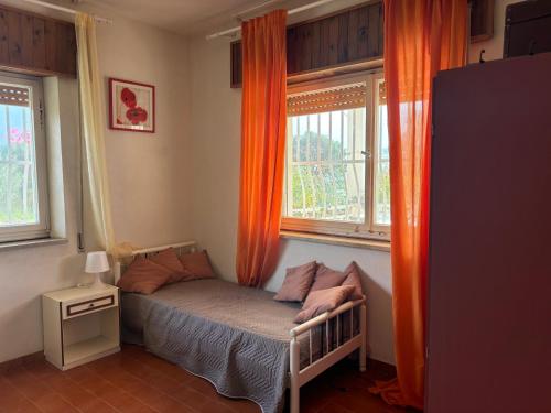 Una cama pequeña en una habitación con dos ventanas. en Ificumori, campagna ammare, en Marina di Modica