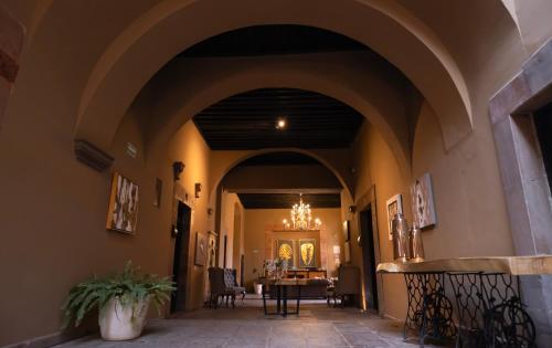 a hallway in a building with a table and chairs at Hotel Plaza de Armas in Querétaro