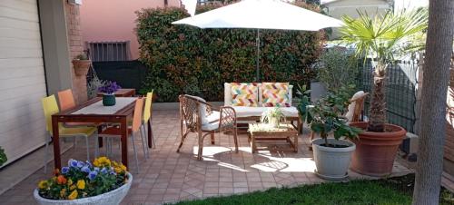 a patio with a table and chairs and an umbrella at B&B Rossorubino in Guastalla