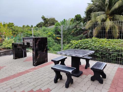 a picnic table and two benches on a patio at Pearl Villa 5 Bedroom Unit 6 in Port Dickson