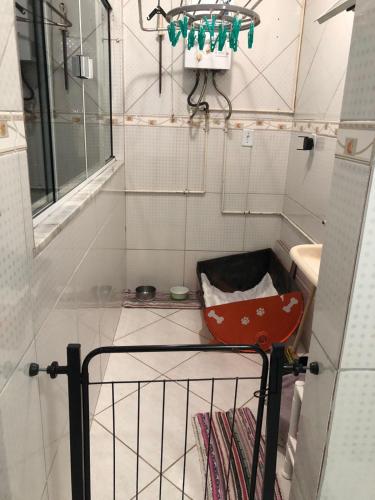 a small kitchen with a sink and a red cart at Apartamento com Wifi, Livros e Espaço Pet in Rio das Ostras
