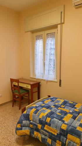 a bedroom with a bed and a desk and a window at Casa per ferie Maria Ausiliatrice in Rome