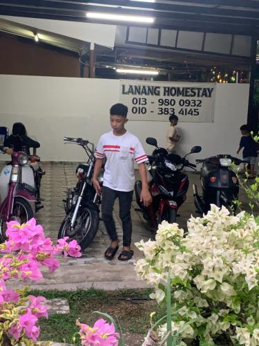a man standing in front of two motorcycles at Lanang Islamic Homestay in Bedung