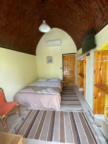 a bedroom with two beds and a flat screen tv at Safari Camp Bahariya Oasis in Bawiti