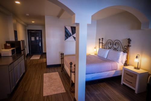 a bedroom with a bed and a kitchen with a microwave at Nuk's Executive Suites in De Pere