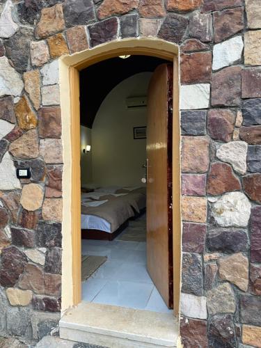 a doorway into a stone wall with a bed at Safari Camp Bahariya Oasis in Bawiti