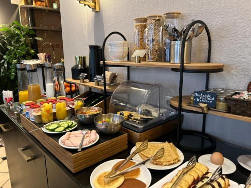 un buffet avec des assiettes de nourriture sur une table dans l'établissement Hôtel Eiffel Rive Gauche, à Paris