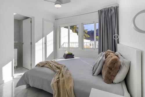 a white bedroom with a large bed and windows at House of dreams in Mogán