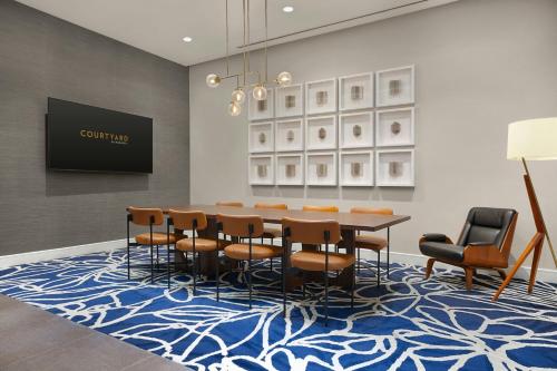 a dining room with a table and chairs on a blue rug at Courtyard by Marriott New York Manhattan/Chelsea in New York
