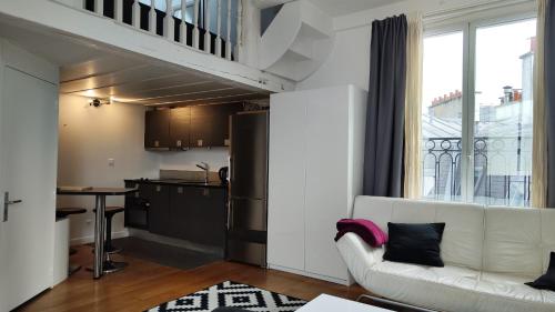 un salon avec un canapé blanc et une cuisine dans l'établissement Avenue Niel - Paris 17 - 2170, à Paris