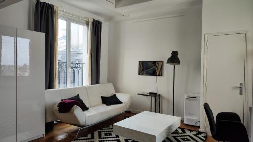 un salon avec un canapé blanc et une table dans l'établissement Avenue Niel - Paris 17 - 2170, à Paris