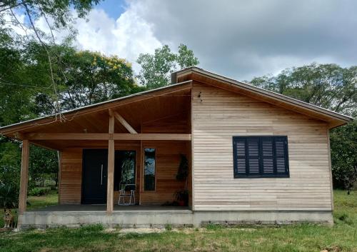una piccola casa in legno con portico di Hospedagem Pantano Grande a Pântano Grande