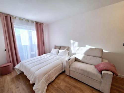 un lit et un canapé dans une chambre dans l'établissement Studio FANTASIA with private car-park - 15min to Disneyland by city bus Number 2233, à Montévrain