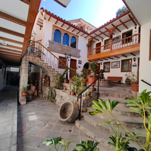 a house with a courtyard with a staircase at Hotel Rumi Punku in Cusco