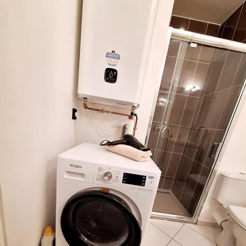 une machine à laver dans une salle de bain avec douche dans l'établissement Studio FANTASIA with private car-park - 15min to Disneyland by city bus Number 2233, à Montévrain