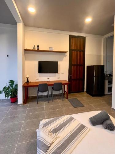 a living room with a television and a table and chairs at Ecohab el paraíso in Barranca de Upía