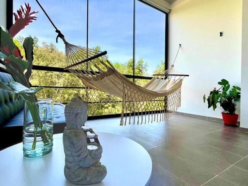 a room with a hammock and a table with a swing at Ecohab el paraíso in Barranca de Upía