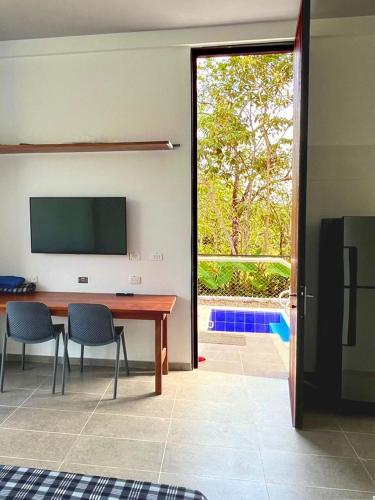 a living room with a table and chairs and a television at Ecohab el paraíso in Barranca de Upía