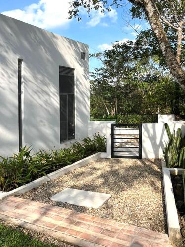 a white house with a black door and a courtyard at Ecohab el paraíso in Barranca de Upía