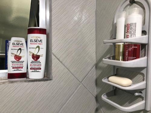 a bathroom with a shelf with some products on it at Apartamento com Wifi, Livros e Espaço Pet in Rio das Ostras